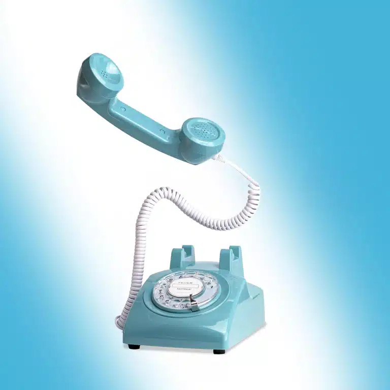 Pastellblaues Retro-Telefon mit Wählscheibe und abgehobenem Hörer
